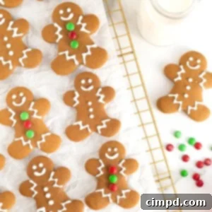 Spiced Gingerbread Delights 13 Six decorated gingerbread man cookies on a parchment lined gold toned cooling rack. Some have green and red M&Ms for buttons.