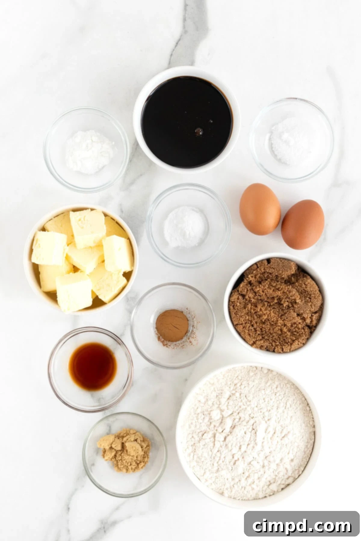 Spiced Gingerbread Delights 6 Ingredients to make gingerbread men cookies in white and glass dishes on a white marble counter.