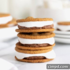 A stack of three s'mores ice cream sandwiches on a white marble surface.