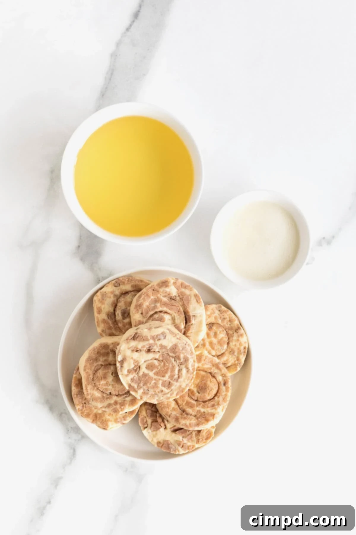Shortcut Cinnamon Roll Donuts 5 Simple ingredients laid out for making quick cinnamon roll donuts, including a can of cinnamon rolls and frying oil.