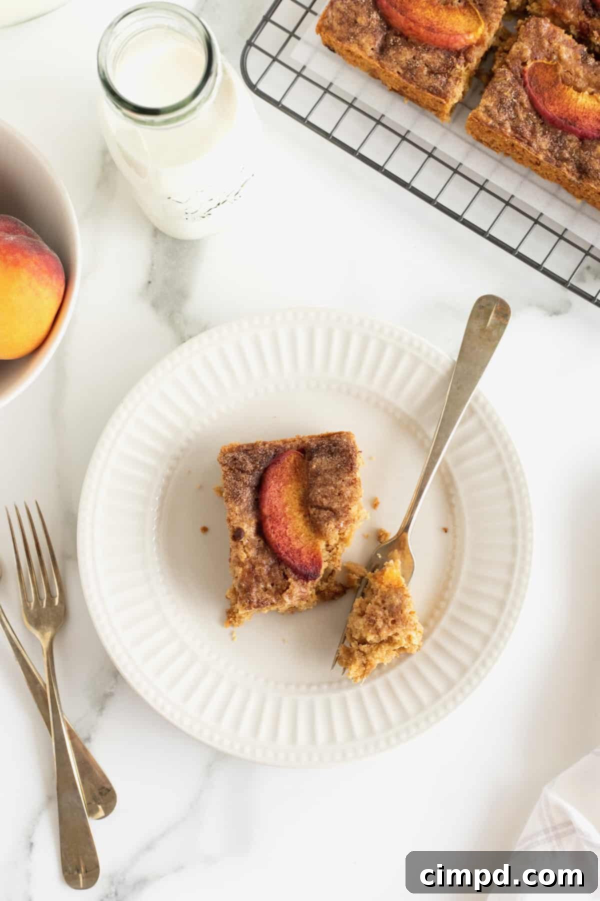 A single peach oatmeal breakfast bar, ready to be enjoyed, served on a plate with a fork.
