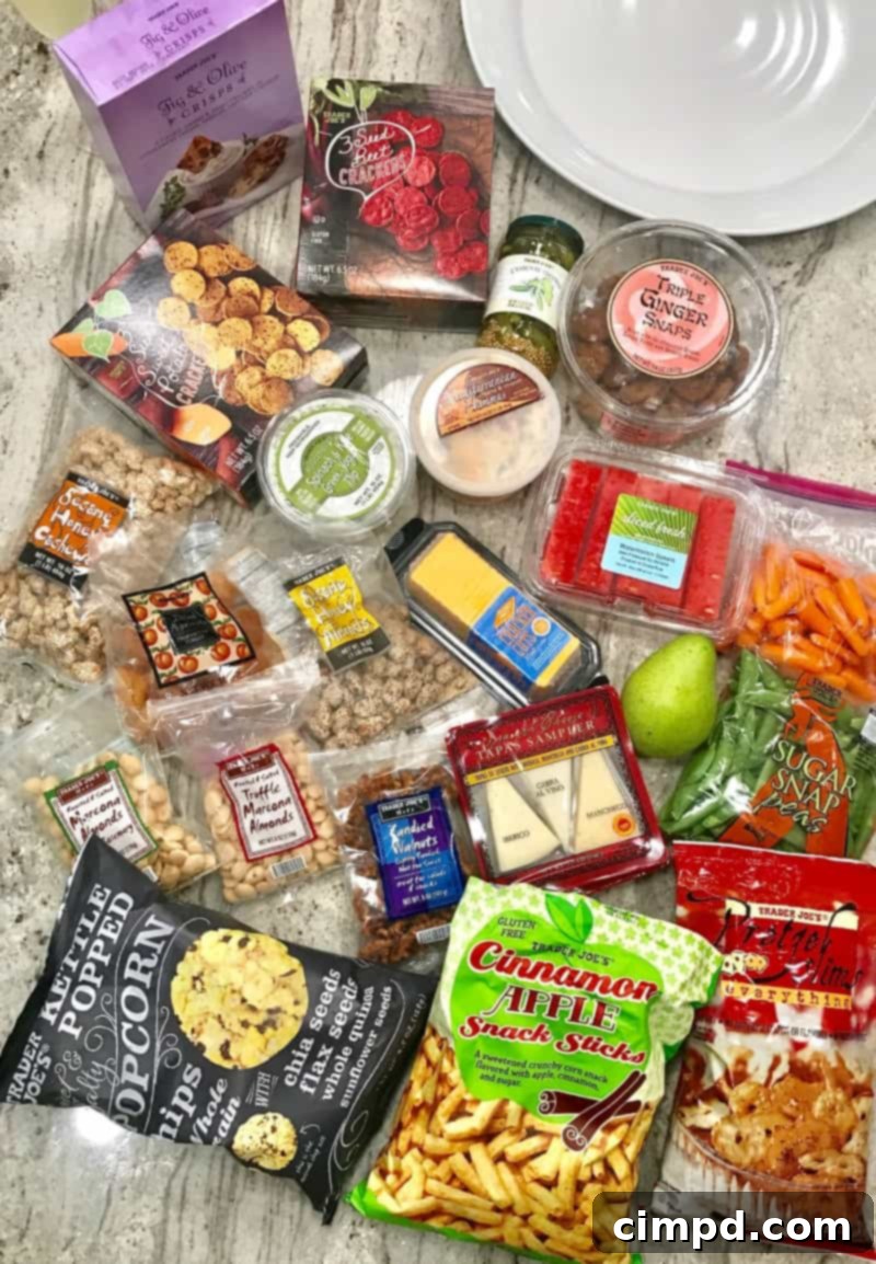 Overhead view of an abundant Trader Joe's snack board featuring crackers, cheeses, fresh produce, and dried fruits