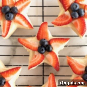 Star-Spangled Celebration Cookies 12 Star shaped shortbread cookies with strawberry slices and blueberries in the center.