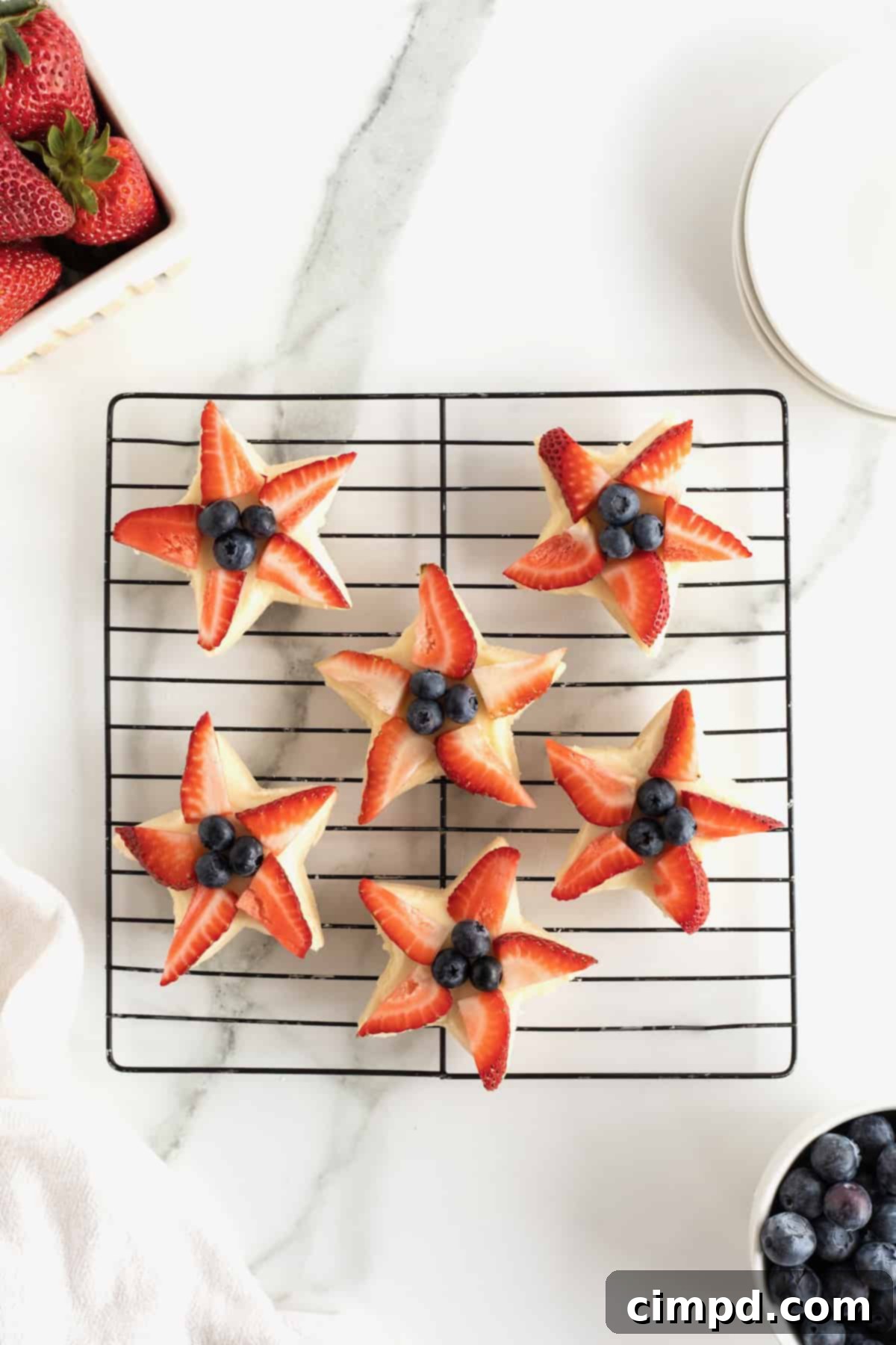 Star-Spangled Celebration Cookies 10 The final decorated star shaped shortbread cookies, featuring fresh strawberry slices and blueberries meticulously placed in the center.