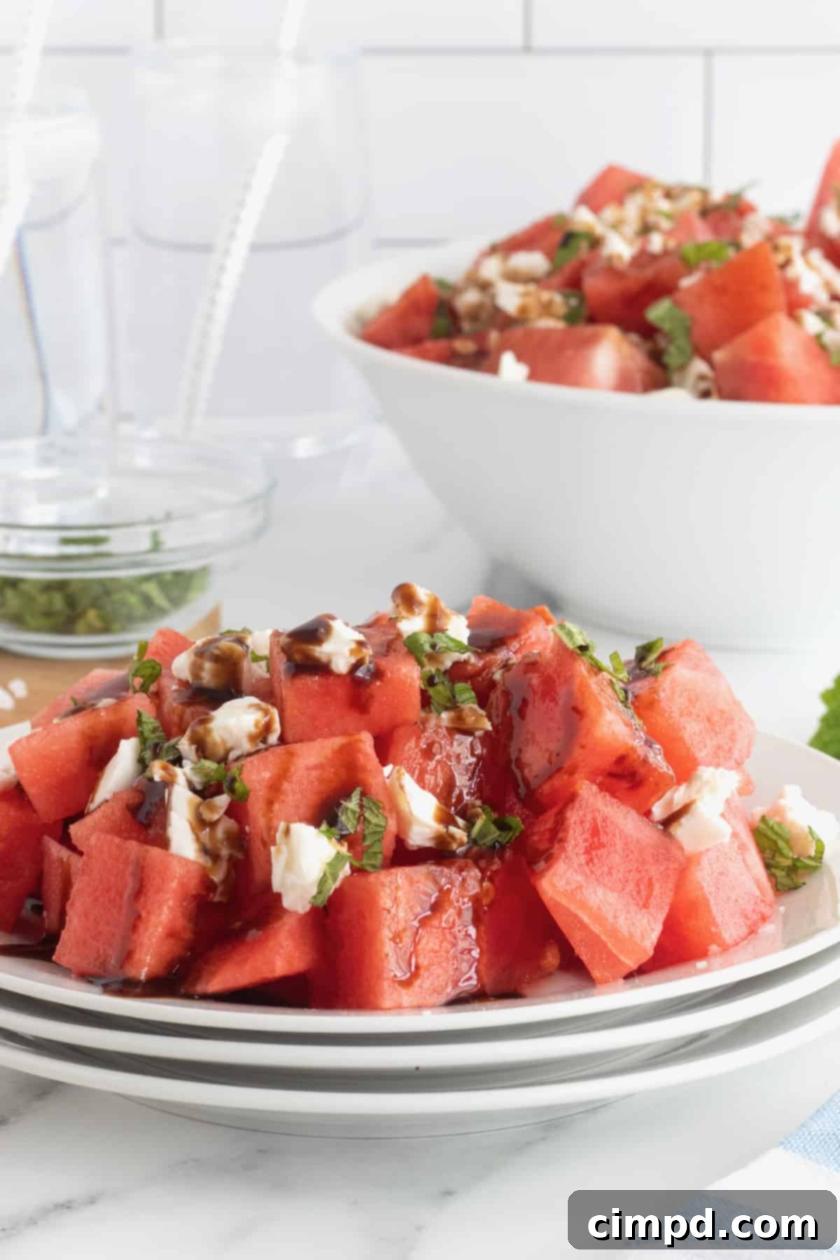 Ingredients for Watermelon Feta Salad laid out, featuring cubed watermelon, feta, and mint.