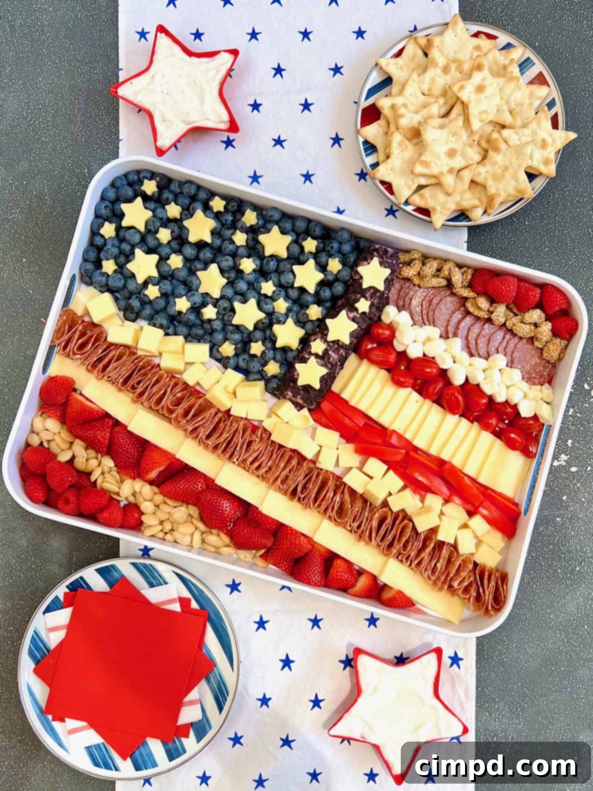 Stars & Stripes Cheese Platter 3 A beautifully arranged cheese tray in the shape of an American flag, featuring various cheeses, fruits, and crackers, ideal for patriotic holiday gatherings.