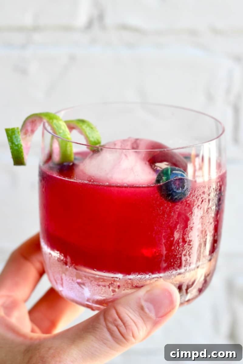 Azure Haze 4 A vibrant Blue Smoke cocktail, showcasing the refreshing combination of mezcal, bourbon, and sweet blueberries.