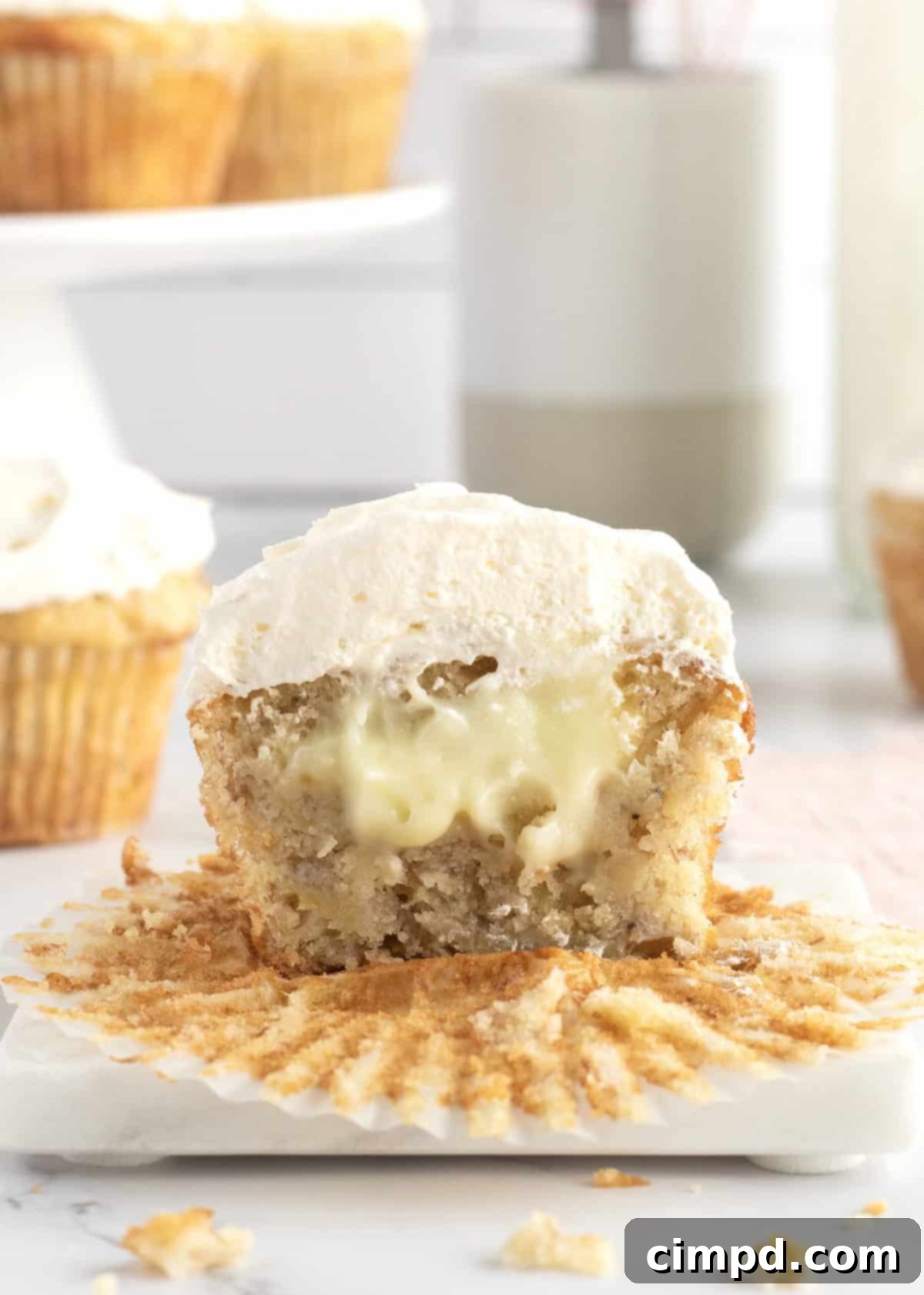 Delicious Banana Pudding Cupcakes by The BakerMama, topped with whipped cream and a vanilla wafer