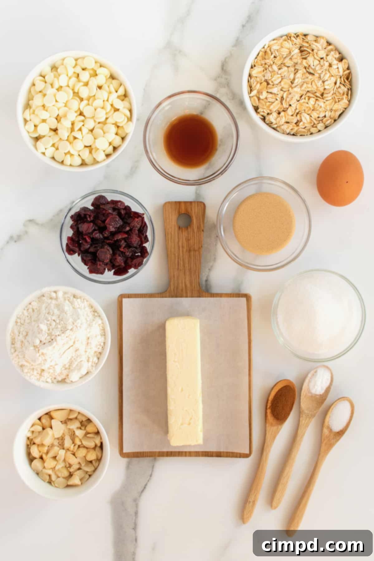 White Chocolate Chip Macadamia Nut Oatmeal Cranberry Cookies 5 Unbaked cookie dough balls on a parchment-lined baking sheet