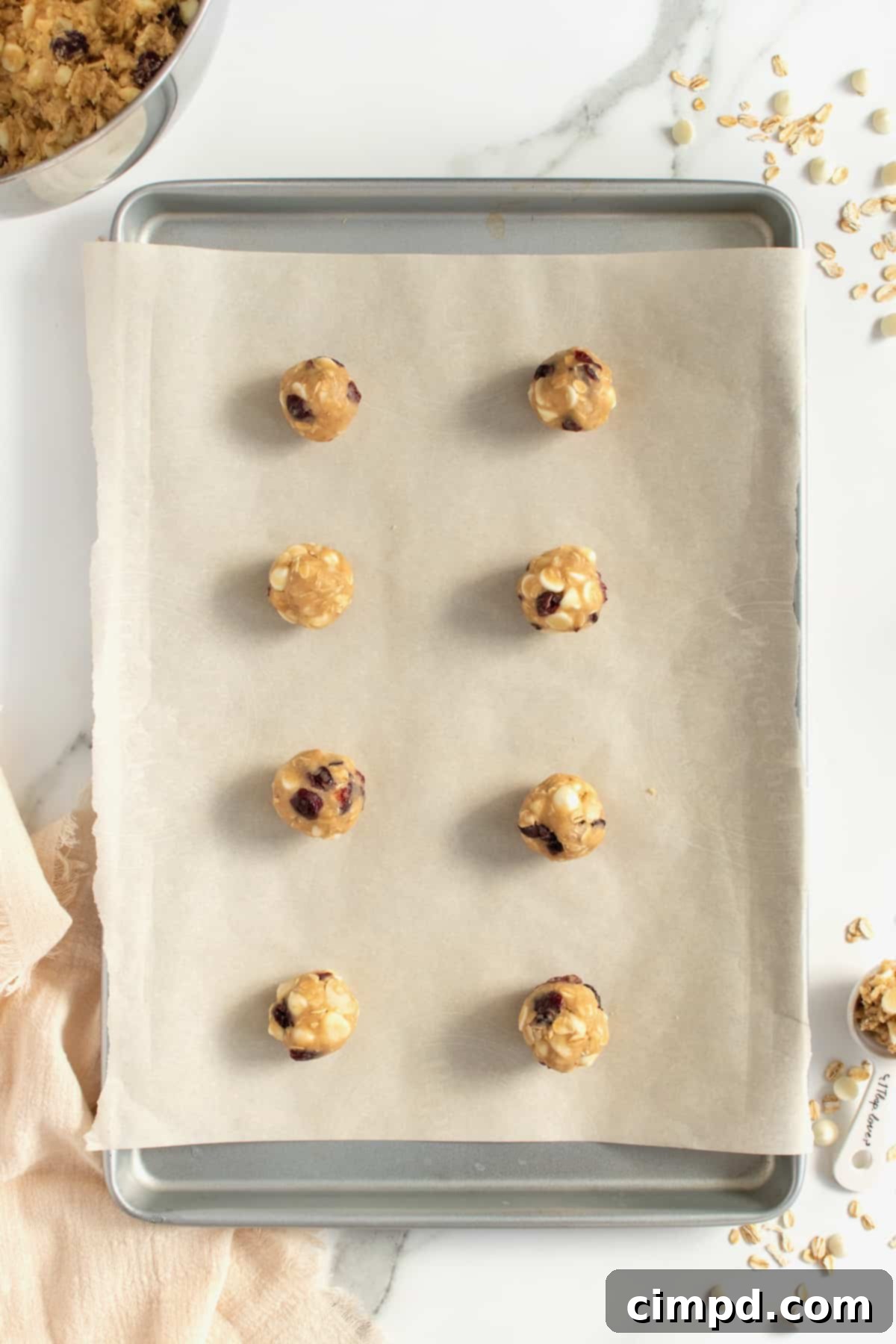 White Chocolate Chip Macadamia Nut Oatmeal Cranberry Cookies 7 Freshly baked Oatmeal Cranberry White Chocolate Chip Macadamia Nut Cookies on a baking sheet