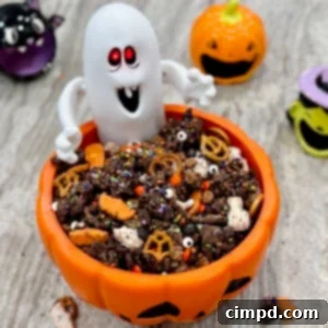 Halloween snack mix in a festive orange jack-o-lantern bowl with a ghost figure.