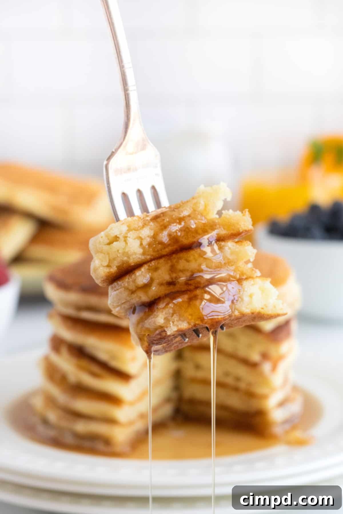 Pancakes cooking on a griddle, showing bubbles on the surface, by The BakerMama