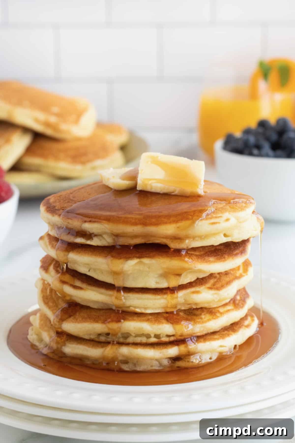 Stack of Classic Buttermilk Pancakes served with butter and maple syrup, by The BakerMama