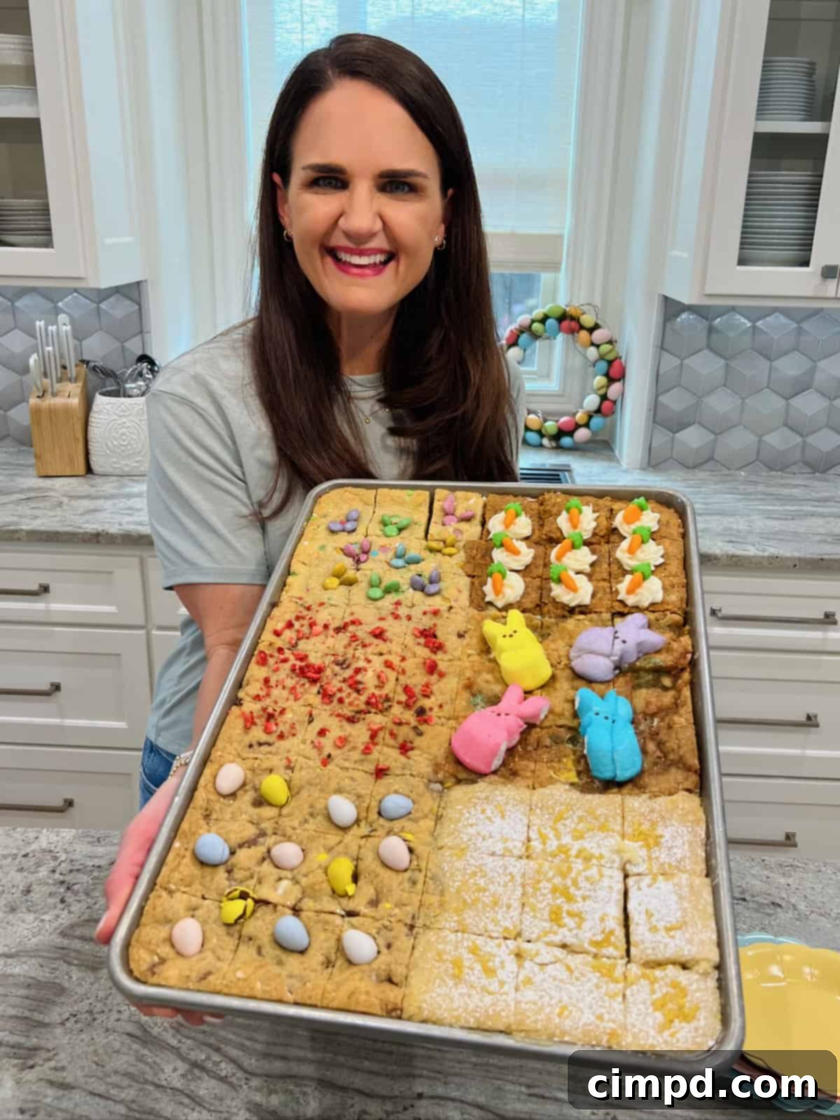 Maegan Brown holding a sheet pan of Easter cookie bars.